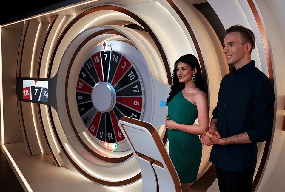 Wheel of Fortune: BetGames' studio photo of the Wheel of Fortune set: two presenters, a woman...